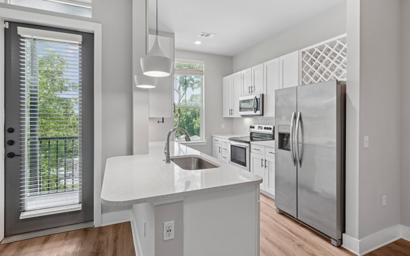 Kitchen with island and counter chairs at Satori West Ashley luxury apartments in West Ashley, SC.